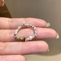 Zilveren kralenring met tijgeroogsteen en parel aan de vinger van een vrouw - Zilver Onregelmatige Kralen Parelring