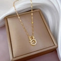 Vista dettagliata della collana in corna di cervo dorata con zircone su portagioie beige - Oro