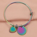 Macro shot of colorful iridescent heart and round charms on adjustable metal bangle - Colorful