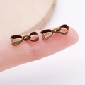 Antique bronze pinch bails for pendants held on a fingertip to show small 3mm size - Bronze