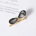 Detail of golden hairpin with dual drop-shaped grey crystals on an elegant background - Black