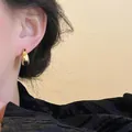 Minimalist chunky U-shaped earrings in polished gold finish on model for daily fashion - E6013 Gold-Hoops (Mirror Polished)