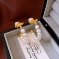 Detalle de pendientes de aro dorados con perlas y motivo floral en un estuche de joyas - Aro en Forma de C con Flores y Perlas (WE3348) / Chapado en Oro Blanco (Pin de Plata S925)