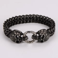 Dettaglio del bracciale gotico da uomo con teschi e catena intrecciata a doppia fila - Nero