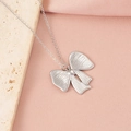 Primo piano di una collana a fiocco argento su sfondo di pietra e tessuto - Stile Fiocco 1 (1#)