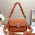 Detail of warm brown embossed handbag with lychee texture leather and a gold twist lock - Earthy Yellow