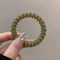 Olive green spiral hair tie with translucent resin finish held in hand - Single Piece / Jelly Green
