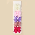 Detailed close-up of 5 colorful ribbed ribbon bow clips on a display card for girls - Style 9