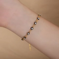Golden Evil Eye bracelet with black and white enamel charms worn on a woman's wrist - Black Enamel Gold Bracelet / 18+4CM