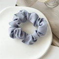 Macro detail of glossy light blue satin scrunchie with soft folds on a white plate - 1 Piece / New Blue