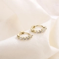 Elegante gouden oorbellen met vijf witte zirkonia's op getextureerde linnen achtergrond - HL-20/Gouden Rij Zirkonia Creool