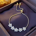 Close-up of gold star flower bracelet with sparkling zircons on purple velvet box - Eco-friendly Star Flower Style