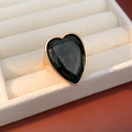 Detail view of heart-shaped dark green gemstone set in a minimalist gold ring mount - Gold-Black