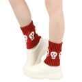 Detail of red knitted boot cuffs featuring white skull patterns and ribbed texture for winter - One Size / Burgundy