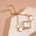 Close-up of golden clover-shaped quartz watch with rhinestones and pull-out bracelet - Bracelet - Gold - White