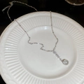 Detail of zircon pendant necklace featuring a clear spherical bead on a white ceramic plate - Vertical Bar Bead Pendant / Silver