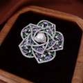 Elegante broche de flor con perla y circonitas de colores en un estuche de joyería - Dorado