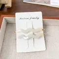 Paire de barrettes à cheveux ondulées en acétate blanc nacré avec attaches dorées - Blanc Irisé 6,8 cm