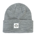 Close-up of gray knitted beanie showing textured yarn and square smiley face patch - Light Heather Grey