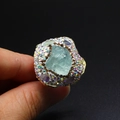 Macro shot of oversized gold ring featuring light blue crystal and amethyst accents - Irregular Raw Stone Open Ring / Aquamarine
