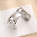 Detailed view of wide open silver titanium steel cuff bracelet with rolled edges on stone - Polished Mirror / B45 Silver Color