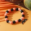Halloween beaded bracelet with black and orange beads and a golden bat charm pendant - Halloween Bat Charm Orange Black