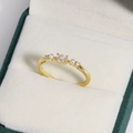 Macro shot of gold ring featuring oval crystal and side pearls on green velvet - Oval Pearl Court Style (Gold 3)