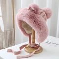 Detail of pink plush faux fur winter hat with cute ears and knit straps on a wooden stand - Pink