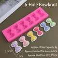 Detailed view of pink 6-cavity bow silicone mold with colorful resin bow examples - 6-Hole Bowknot