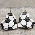 Macro detail of heart-shaped faux leather earrings with a black and white soccer pattern - Football