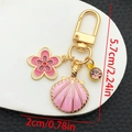 Llavero de metal con concha y flor rosa con dimensiones de 5,7cm de largo total - Esmalte Rosa (ER1276)