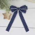 Detail van een marineblauwe denim strik met witte golvende ric-rac randen op houtdecor - Donkerblauw