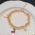 Pulsera dorada con dijes de cerezas rojas, una perla blanca y un colgante de hoja fina - Pulsera de Hoja de Perla y Cereza Dorada (A-1160)