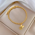 Macro detail of golden bead bracelet featuring a hollow rabbit charm with Fu character - Titanium Steel / Gold