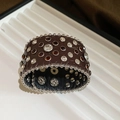 Close-up of wide embossed leather bracelet with white and amber crystal studs - Brown
