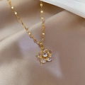 Macro view of a gold flower pendant with clear zircon crystals on a flat link chain - Gold Flower Zirconia Pendant Style (G233)