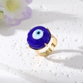 Makroaufnahme des vergoldeten Evil Eye Rings mit blauem Glasauge auf Steinfläche - Einstellbar Offen / Königsblaues Auge