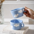 Detail of hand-pinched ceramic mug with blue finish and white cloud pattern - White Clouds