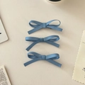 Gros plan de trois barrettes à nœuds en satin bleu disposées sur une surface blanche - Ensemble de 3 / Bleu Brumeux