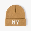 Close-up of white NY embroidery on a warm caramel-colored knitted beanie cap - One Size / Khaki