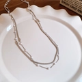 Primer plano del collar de doble capa plateado con perlas en un plato cerámico - Estilo Perla 3mm (HN7834) / Plateado