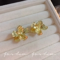 Golden flower earrings with hammer texture in a cream velvet jewelry box display - A1700 Gold Textured Flower