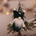 Green Christmas gnome ornament with snowflake embroidery hanging on snowy tree branch - Dark Green Faceless Gnome Pendant