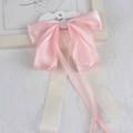 Elegant pink satin ribbon bow hair clip with translucent lace streamers on display - Champagne