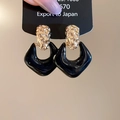 Detalle de pendientes martillados dorados con colgantes de esmalte negro brillante - Negro
