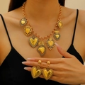 Vintage-Schmuckset aus Gold mit strukturierten Herzanhängern an einem Model getragen - Halskette Und Ohrringe (0457+2966) / Altgold
