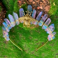 Detailed close-up of blue crystal crown headpiece with a brass bee on mossy forest background - Blue Purple Crystal Bee