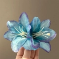 Elegant blue and purple gradient lily flower hair clip held by hand for a detailed view - Type A Blue Lily Hair Clip