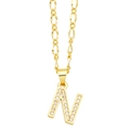 Macro detail of gold letter N pendant with pavé cubic zirconia on Figaro chain necklace - Letter N