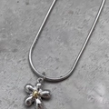 Minimalistische silberne Blumenkette mit goldener Mitte auf einer Schlangenkette - Blumenstil / Silber/Gold